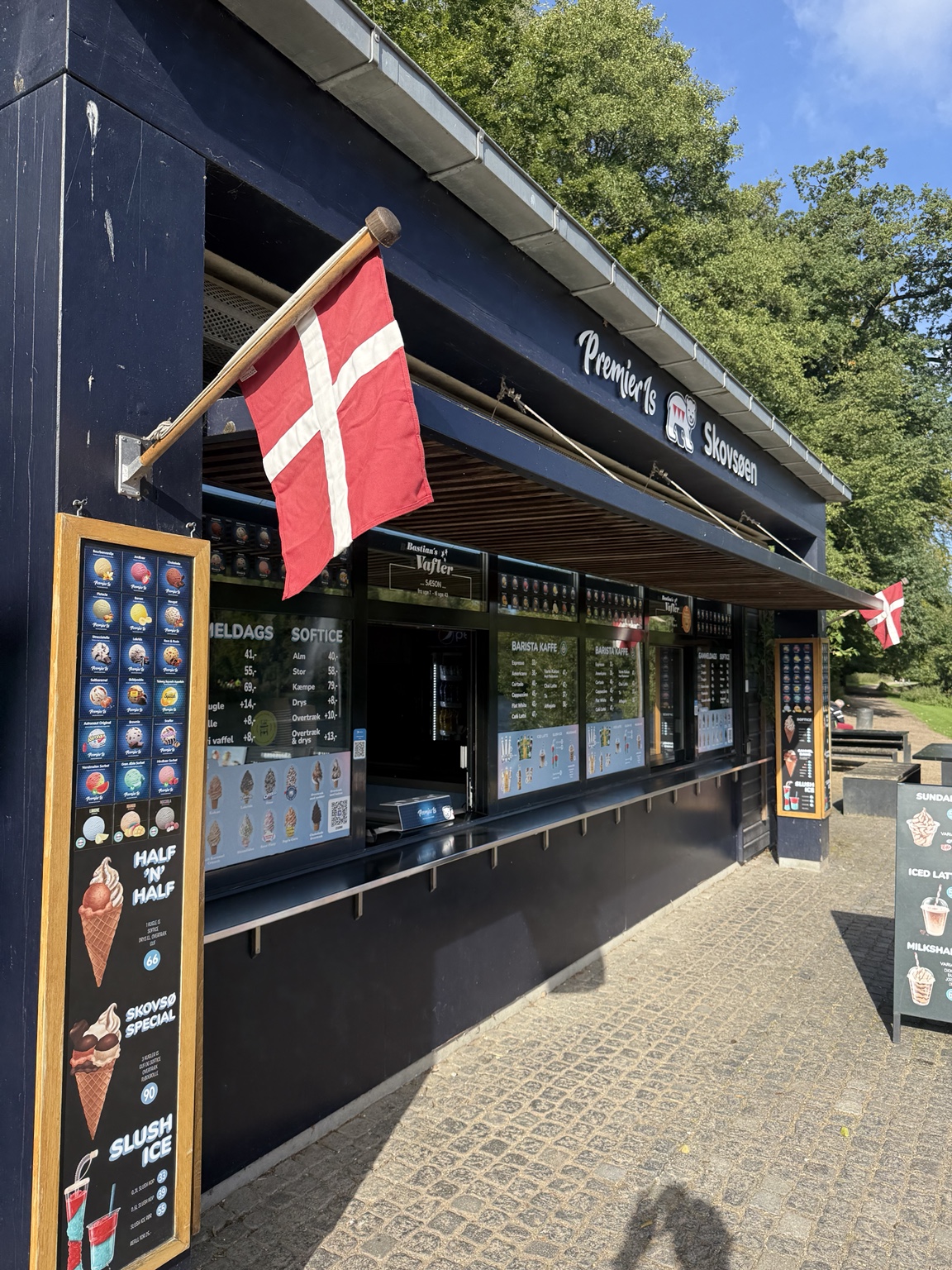 Vaffelhuset Skovsøens facade med Dannebrog og isdisken mod skoven